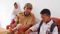 Yudding (12) dan adiknya Nursabbi (11) berbincang dengan guru saat berada di sekolah. Foto: (Agung Pramono/detikSulsel)