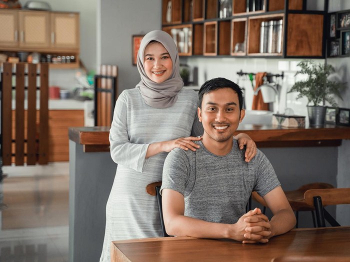 portrait of muslim couple sitting in dining room together