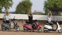 Sejumlah orang melakukan yoga dari atas motor di kawasan Ahmedabad, India.