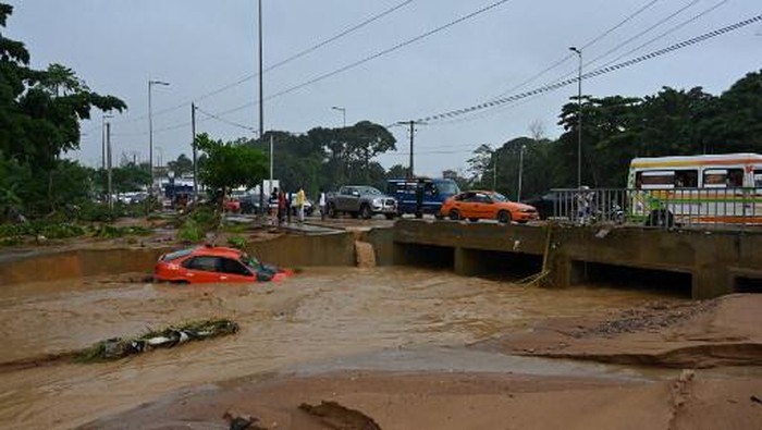 Residents clear debris from their homes in Bingerville near Abidjan after torrential rain on June 21, 2022. (Photo by Issouf SANOGO / AFP)