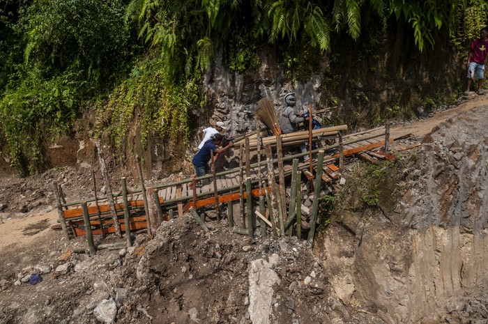 JALAN DARURAT SWADAYA MASYARAKAT Pengendara roda dua melintasi jalan darurat yang dibangun swadaya di Cikulur, Lebak, Banten, Senin (20/6/2022). Sejak dua pekan terakhir jalan yang menghubungkan Kabupaten Lebak dan Pandeglang tersebut kondisinya rusak parah akibat tanah amblas sehingga warga setempat berinisiatif membangun jalan darurat secara swadaya untuk lalu lintas warga. ANTARA FOTO/Muhammad Bagus Khoirunas/rwa.