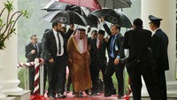 Momen Presiden Joko Widodo berjalan bersama Raja Arab Saudi Salman bin Abdul Aziz di tengah hujan saat keduanya bertemu di Istana Kepresidenan Bogor, Jawa Barat, tahun 2017 lalu. (ACHMAD IBRAHIM/AFP via Getty Images).