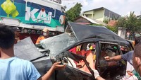 Petugas bersama warga masih berupaya mengevakuasi jenazah korban. Mobil berwarna hitam itu tampak ringsek akibat tertabrak kereta. (Fakhri F/detikcom)