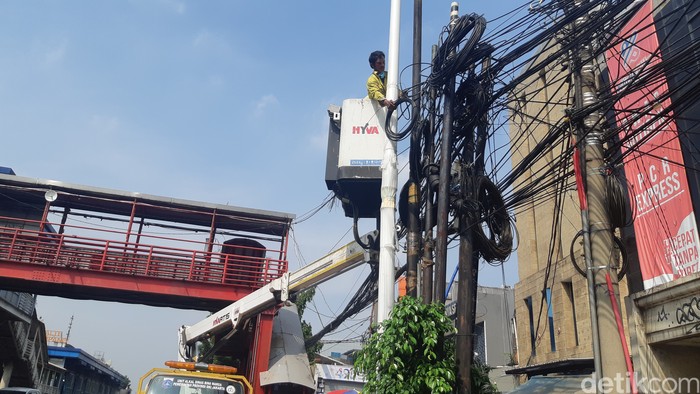 Pemotongan kabel udara di Jl Mampang Prapatan Raya Jaksel oleh Dinas Bina Marga DKI, 21 Juni 2022. (Danu Damarjati/detikcom)