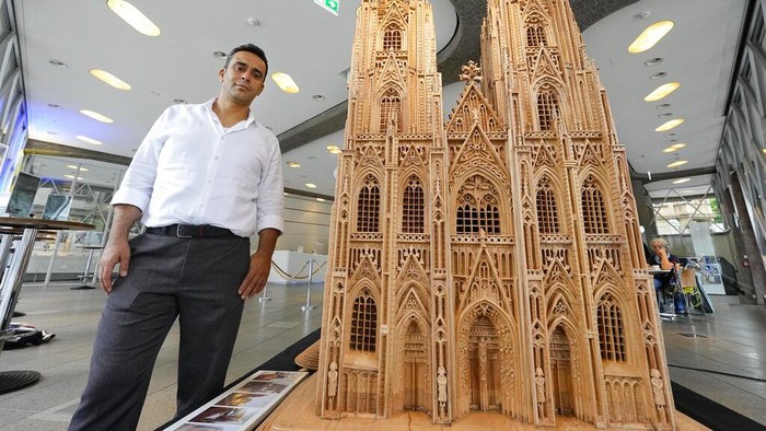 Pengungsi Suriah di Jerman Bikin Miniatur Gereja Cologne, Persis Banget Aslinya Fadel Alkhudr from Syria poses beside his wooden model of the word heritage Cologne Cathedral on display at the Domforum in Cologne, Germany, Monday, June 20, 2022. Fadel Alkhudr, 42, a woodcarver and artist orginally from Aleppo, Syria, fled the war in his home country and arrived in the western german city of Cologne in 2015. In 2019 he started to carve the local Cologne Cathedral in his small basement - without any plans or drawings, using only cell phone photos of the cathedral as a template. (AP Photo/Martin Meissner)