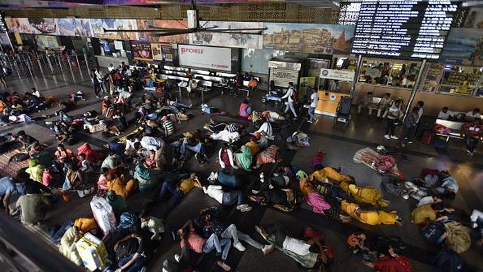 Penumpang Kereta Terdampar di Stasiun Imbas Gelombang Demonstrasi NEW DELHI, INDIA - JUNE 20: Passengers Waiting at New Delhi Railway Station as Indian Railway cancelled number of trains in the wake of violent protest against Agnipath Scheme on June 20, 2022 in New Delhi, India. Protests have erupted in several states since Wednesday against the Agnipath scheme to recruit jawans into the army, the navy and the air force for a four-year-period followed by compulsory retirement for most without gratuity and pension benefits. Today, various protesting groups have called for a Bharat Bandh against the Agnipath recruitment scheme, with several state governments tightening their security.(Photo by Sonu Mehta/Hindustan Times via Getty Images)