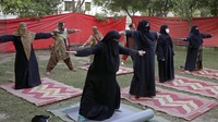 Para wanita berlatih yoga pada malam Hari Yoga Internasional di Lahore, Pakistan, Selasa (21/6/2022). (AP Photo/K.M. Chaudary)