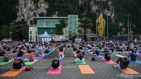 Penggemar yoga melakukan yoga selama acara yang diselenggarakan oleh Komisi Tinggi India di Malaysia untuk menandai Hari Yoga Internasional di kuil Batu Caves, Gombak, Kuala Lumpur, Malaysia, Selasa (21/6/2022). (Mohd Rasfan/AFP)  