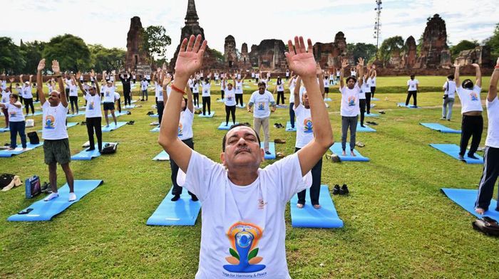 People take part in an event to celebrate the International Day of Yoga organized by the Indian Embassy, in front of Wat Mahatat Buddhist temple in Ayutthaya on June 21, 2022. (Photo by Lillian SUWANRUMPHA / AFP) (Photo by LILLIAN SUWANRUMPHA/AFP via Getty Images)