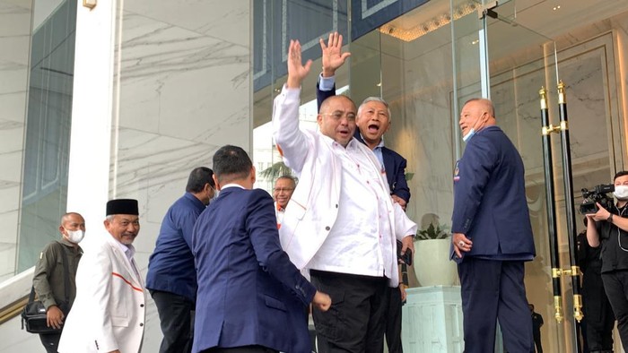 Sekjen PKS Aboe Bakar Alhabsy yang mengenakan seragam kebesaran PKS warna putih melambaikan tangan ke wartawan, di NasDem Tower, Jakarta Pusat, Rabu (22/6/2022).