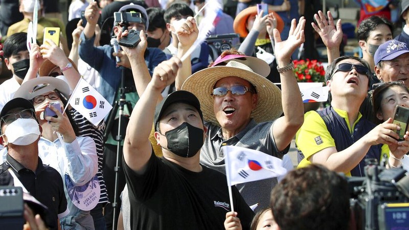 People watch the Nuri rocket, the first domestically produced space rocket, taking off from the launch pad near the Naro Space Center in Goheung, South Korea, Tuesday, June 21, 2022. South Korea launched its first domestically built space rocket on Tuesday in the country's second attempt, months after its earlier liftoff failed to place a payload into orbit. (Chun Jung-in/Yonhap via AP)