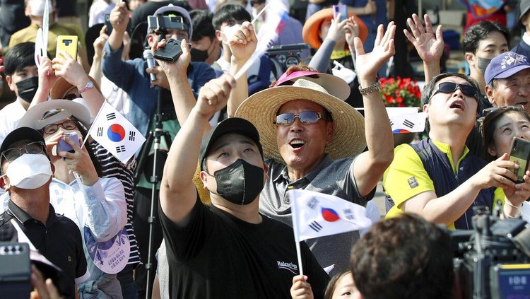 Antusias Warga Korsel Tengok Peluncuran Roket Luar Angkasa People watch the Nuri rocket, the first domestically produced space rocket, taking off from the launch pad near the Naro Space Center in Goheung, South Korea, Tuesday, June 21, 2022. South Korea launched its first domestically built space rocket on Tuesday in the countrys second attempt, months after its earlier liftoff failed to place a payload into orbit. (Chun Jung-in/Yonhap via AP)