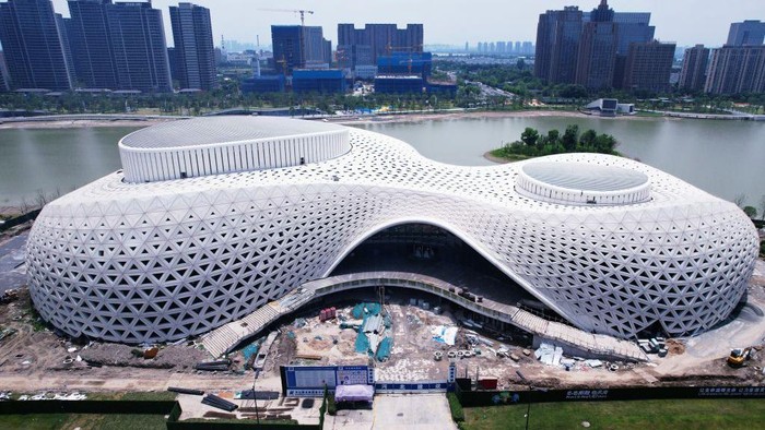 Gedung Teater di Tepi Danau Ini Selesai Dibangun, Desainnya Futuristik Banget HANGZHOU, CHINA - JUNE 22, 2022 - An aerial view of the completed facade of the Hangzhou Jinsha Lake Grand Theater in Hangzhou, East China's Zhejiang Province, on June 22, 2022. With a total construction area of about 44,000 square meters, Hangzhou Jinsha Lake Grand Theater is divided into two areas, 1400 theater halls and 500 multi-function halls, which are connected by a shared hall. The theatre will become the most important cultural landmark in the eastern part of Hangzhou. (Photo credit should read CFOTO/Future Publishing via Getty Images)