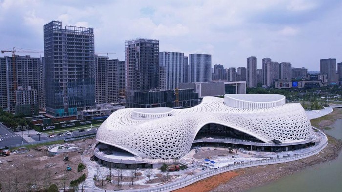 Gedung Teater di Tepi Danau Ini Selesai Dibangun, Desainnya Futuristik Banget HANGZHOU, CHINA - JUNE 22, 2022 - An aerial view of the completed facade of the Hangzhou Jinsha Lake Grand Theater in Hangzhou, East China's Zhejiang Province, on June 22, 2022. With a total construction area of about 44,000 square meters, Hangzhou Jinsha Lake Grand Theater is divided into two areas, 1400 theater halls and 500 multi-function halls, which are connected by a shared hall. The theatre will become the most important cultural landmark in the eastern part of Hangzhou. (Photo credit should read CFOTO/Future Publishing via Getty Images)
