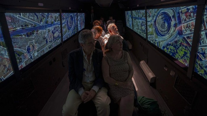 Jelajah Kota Roma Kuno dengan Virtual Bus di Italia, Mau Ikut? Journalists participating in the first tour of the Imperial Rome - Virtual Reality Bus look at 3D VR images of ancient Rome during the project presentation to the media in downtown Rome, Tuesday, June 21, 2022. The virtual tour of ancient Rome, includes the Roman Forum, the Colosseum, the Palatine Hill, the Circus Maximus, and the Theater of Marcellus, in a 3D immersion with special