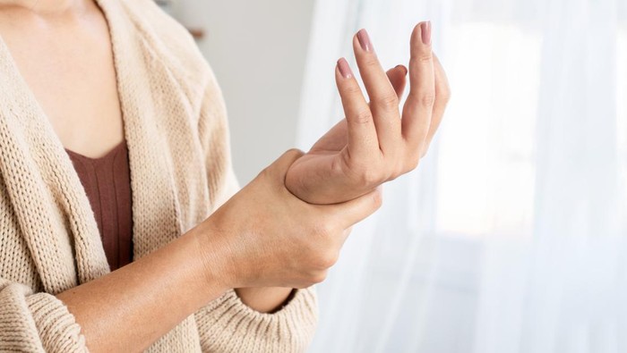 kolesterol woman suffering from wrist pain, numbness, or Carpal tunnel syndrome hand holding her ache joint
