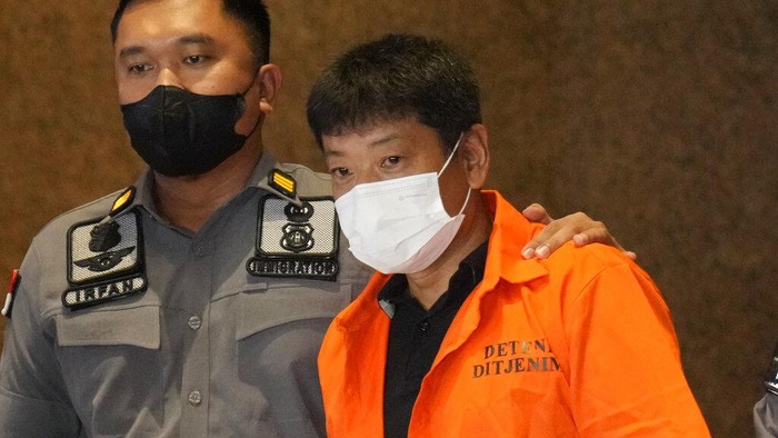 Immigration officers escort Japanese fugitive Mitsuhiro Taniguchi, center, who was arrested on Sumatra island in early June, prior to his deportation in Jakarta, Indonesia, Wednesday, June 22, 2022. Indonesia on Wednesday deported Taniguchi who was wanted by Japanese police for COVID-19 subsidy fraud. (AP Photo/Dita Alangkara)