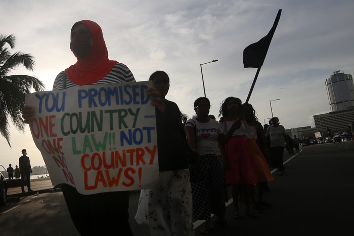 Sri Lankan anti-government protesters hold placards and  join hands to form a  human chain at Gotagogama at Galle face green, Colombo, Sri Lanka. 18 June 2022. (Photo by Tharaka Basnayaka/NurPhoto via Getty Images)