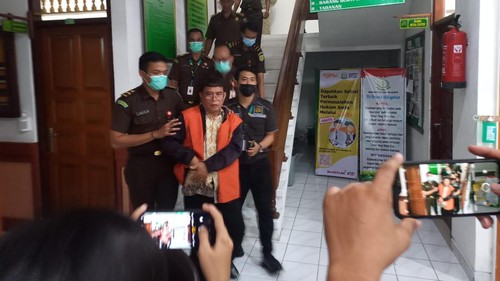 Tersangka NAW saat digiring menuju ke mobil tahanan oleh penyidik Kejaksaan Negeri (Kejari) Buleleng, Rabu (22/6/2022).