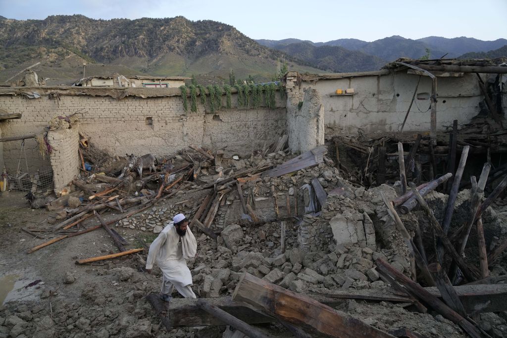 Men stand around the bodies of people killed in an earthquake in Gayan village, in Paktika province, Afghanistan, Thursday, June 23, 2022. A powerful earthquake struck a rugged, mountainous region of eastern Afghanistan early Wednesday, flattening stone and mud-brick homes in the country's deadliest quake in two decades, the state-run news agency reported. (AP Photo/Ebrahim Nooroozi)