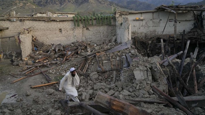 2.000 Rumah Hancur Imbas Gempa Bumi Afghanistan Men stand around the bodies of people killed in an earthquake in Gayan village, in Paktika province, Afghanistan, Thursday, June 23, 2022. A powerful earthquake struck a rugged, mountainous region of eastern Afghanistan early Wednesday, flattening stone and mud-brick homes in the country's deadliest quake in two decades, the state-run news agency reported. (AP Photo/Ebrahim Nooroozi)