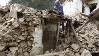 Penampakan seorang warga yang mencoba mengumpulkan barang-barang berharga yang dapat diselamatkan dari rumahnya yang rusak berat akibat gempa M 5,9 yang mengguncang wilayah timur Afghanistan. (AP Photo).
