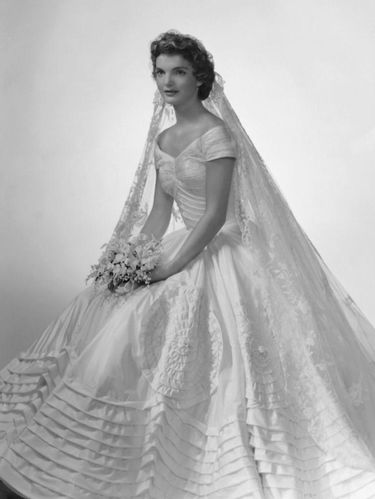 Bridal portrait of Jacqueline Lee Bouvier (1929 - 1994) shows her in an Anne Lowe-designed wedding dress, a bouquet of flowers in her hands, New York, New York, 1953. (Photo by Bachrach/Getty Images)