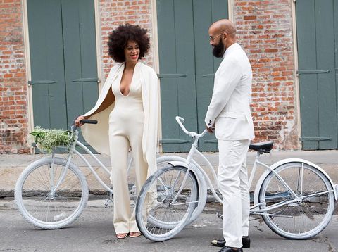 NEW ORLEANS, LA - NOVEMBER 16: Musician Solange Knowles (wearing a pre-ceremony ensemble by Stephane Rolland) and her fiance, music video director Alan Ferguson, ride bicycles on the streets of the French Quarter en route to their wedding ceremony at the Marigny Opera House on November 16, 2014 in New Orleans, Louisiana. (Photo by Josh Brastead/WireImage)