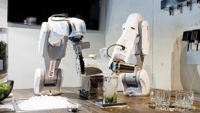 Kenalan dengan Robot Bartender, Jago Bikin Koktail A robot places a drinking straw into a mojito cocktail at the Sausalitos bar in Munich, Germany, June 21, 2022. The robot, which consists of two arms, is designed to relieve the bar staff by mixing cocktails fully automatically. REUTERS/Lukas Barth
