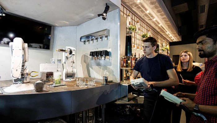 Kenalan dengan Robot Bartender, Jago Bikin Koktail A robot places a drinking straw into a mojito cocktail at the Sausalitos bar in Munich, Germany, June 21, 2022. The robot, which consists of two arms, is designed to relieve the bar staff by mixing cocktails fully automatically. REUTERS/Lukas Barth