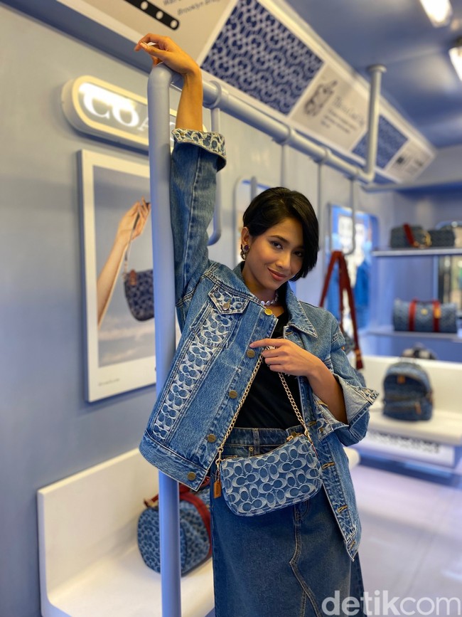 Dengan konsep denim on denim, busana pilihannya terdiri dari jaket denim bermotif monogram Coach, rok denim, dan handbag senada. Semuanya merupakan bagian dari koleksi PreFall 2022 Coach. (Foto: Daniel Ngantung/Wolipop)
