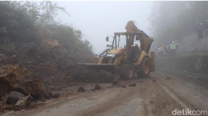 Alat berat saat membersihkan material longsor yang menutupi jalan di Kawasan Sitinjau Lauik, Kamis (23/6/2022). (Jeka/detikSumut)
