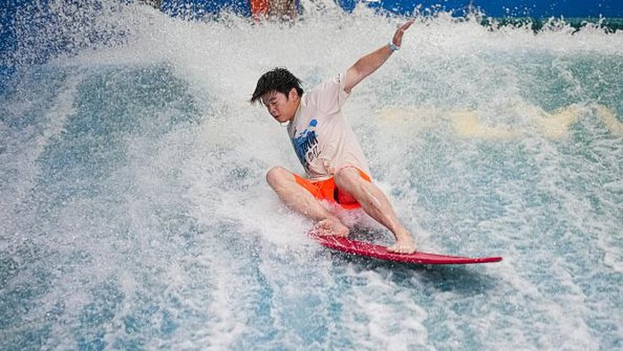 Menikmati Musim Panas di China dengan Selancar Dalam Ruangan BEIJING, CHINA - JUNE 22: A man practices surfing in a Surfing Club on June 22, 2022 in Beijing, China. All sports and fitness facilities in Beijing have reopened to the public at 75 percent customer capacity. (Photo by Fred Lee/Getty Images)