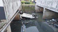 Kondisi jalan menurun kemudian membuat kendaraan oleng. Mobil Fortuner kemudian menabrak separator jalan dan berakhir nyemplung ke kali.