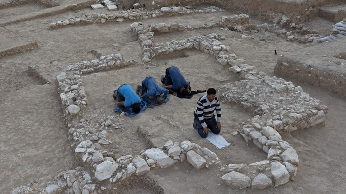 Muslim Palestinian workers of Israels Antiquities Authority pray amid the remains of a recently discovered ancient mosque, which dates back to the early Islamic period, in the Bedouin town of Rahat in Israels southern Negev desert on June 22, 2022. - The discovery of the site, which dates back to the period between the seventh and eighth centuries, was made in a few years ago during extensive archeological excavations conducted by the Israel as part of a plan to expand southern Rahat with state funding, through the Bedouin Development and Settlement Authority in the Negev. (Photo by MENAHEM KAHANA / AFP)
