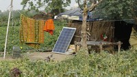 Sebuah panel surya ditempatkan begitu saja di atas tanah di permukiman sepanjang sungai Yamuna di New Delhi, India, Rabu (22/6/2022). Tidak terlihat instalasi standar panel surya seperti besi penopang.  