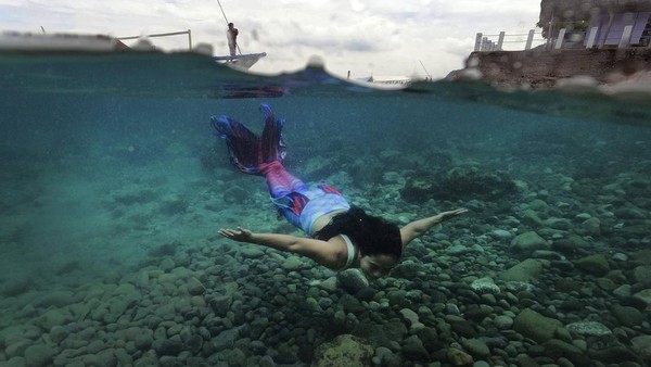 Filipina Jennica Secuya berenang dengan mengenakan kostum putri duyung saat mengikuti kelas putri duyung di Mabini, Provinsi Batangas, Filipina, Minggu (22/5) lalu. (Aaron Favila/AP Photo).