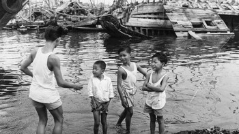 Anak-anak kecil bermain di pelabuhan pada sekitar tahun 1963. Mereka berpakaian ala kadarnya layaknya anak desa. Foto: Getty Images