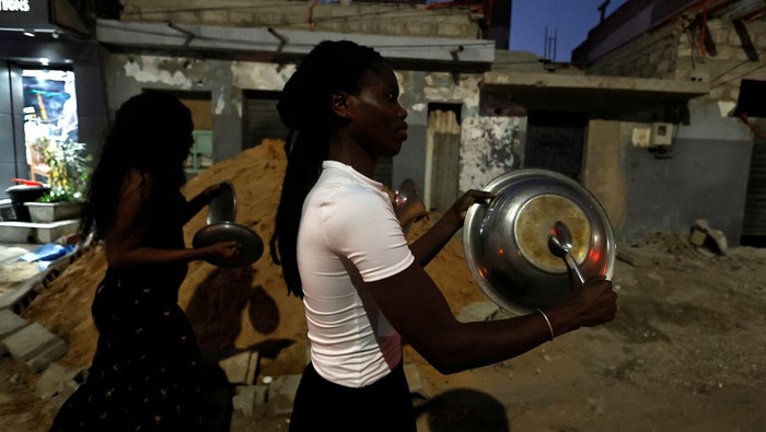 Ibrahima Soumare, 47, a supporter of Senegal's main opposition coalition Yewwi Askan Wi holds signs glued on pot lids during a protest over the disqualification of their national list for the July 31 legislative election in Dakar, Senegal, June 22, 2022. REUTERS/Zohra Bensemra