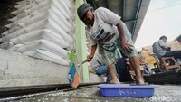 Di tengah terik matahari yang menyengat, dengan gigih Nenek Nurhayati menyapu beras-beras yang sudah bercampur dengan debu.