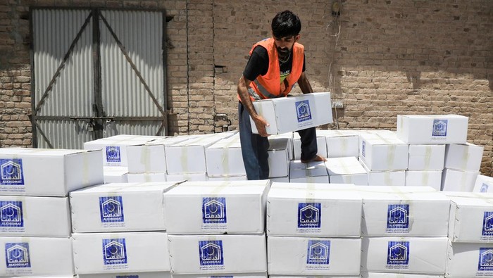 Bantuan untuk Korban Gempa Afghanistan Mulai Berdatangan A volunteer from the Al-Khidmat Foundation walks past trucks loaded with food supplies for the people affected by the earthquake in Afghanistan, in Peshawar, Pakistan June 23, 2022. REUTERS/Fayaz Aziz