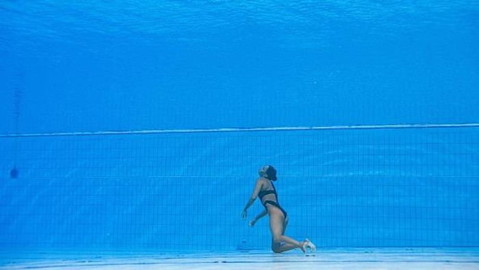 TOPSHOT - USA's coach Andrea Fuentes (R) swims to recover USA's Anita Alvarez (L), from the bottom of the pool during an incident in the women's solo free artistic swimming finals, during the Budapest 2022 World Aquatics Championships at the Alfred Hajos Swimming Complex in Budapest on June 22, 2022. (Photo by Oli SCARFF / AFP) (Photo by OLI SCARFF/AFP via Getty Images)