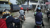Seorang penjaga perlintasan terus memberikan aba-aba ketika ada kereta yang akan melintas.