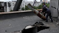 Dua orang anggot tim khusus memindahkan sebuah bom seberat 500 kilogram yang gagal meledak di Kharkiv, Ukraina, Kamis (23/6/2022) waktu setempat.