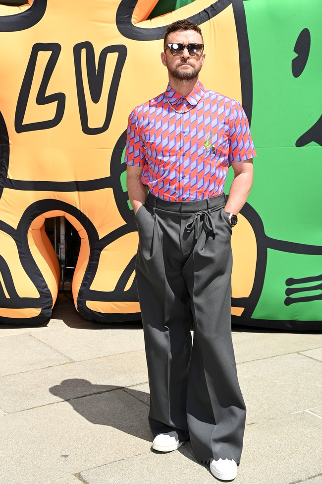 Justin Timberlake pun kalah stylish. Ia memadukan kemeja dengan celana high-waist model gombrong dengan keliman zig-zag yang unik. Sepasang sneakers putih menjadi alas kaki andalan. (Foto: Getty Images For Louis Vuitton/Pascal Le Segretain)
