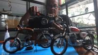 Kerajinan miniatur motor jadul ini dibuat dari bahan dasar lembaran timah, kawat, pipa peralon, dan spons.  