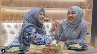Saling kompak mengenakan pakaian serba biru. Nathalie dan Putri menyantap sate ayam bumbu kacang dengan tambahan lontong. Foto: YouTube/Instagram