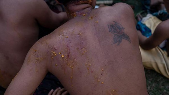 BALI, INDONESIA - JUNE 23: Two Balinese men fight each other using pandanus leaf and rattan shield during the pandanus war ritual called Mekare-kare on June 23, 2022 in Tenganan Pegringsingan Village, Bali, Indonesia. The ancient 