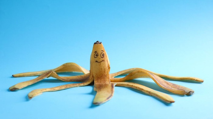 mr p Banana peel with drawn happy face on light blue background