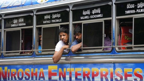 A man holds a cup of tea and walks past autorickshaws waiting in a queue to fill fuel in Colombo, Sri Lanka, Friday, June 24, 2022. Sri Lankans have endured months of shortages of food, fuel and other necessities due to the country’s dwindling foreign exchange reserves and mounting debt, worsened by the pandemic and other longer term troubles. (AP Photo/Eranga Jayawardena)
